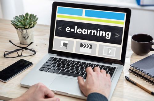 Man working on a laptop with the word e-learning on the computer screen