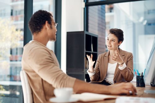 Mentor, training and a woman manager with an employee in the office for coaching on company vision. Management, meeting and a female business person talking to a professional male colleague at work