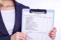 ストレスチェック用紙を持つ女性