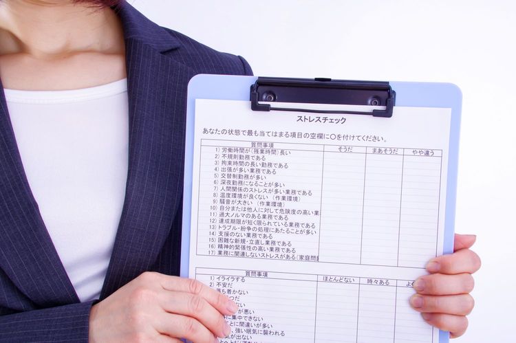 ストレスチェック用紙を持つ女性