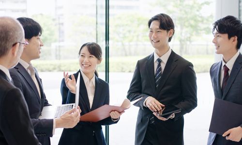 ロビーで話をするビジネスパーソンとインターン学生